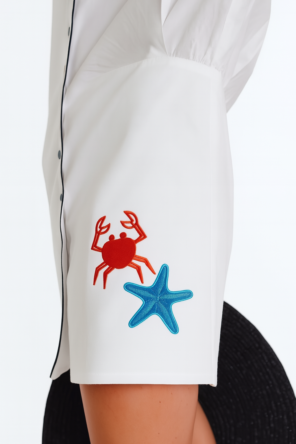 White shirt with red crab and blue starfish design on a white background